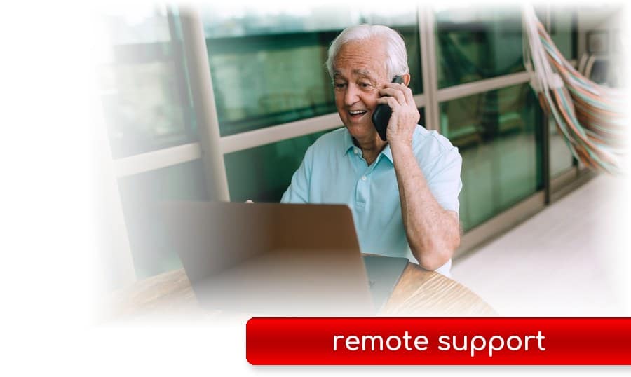 Man on the phone smiling at his laptop - remote computer support